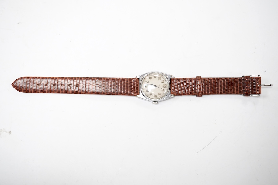 A gentlemen's mid 20th century stainless steel Rolco manual wind wrist watch, with Arabic dial, the case back with engraved monogram and numbered 595943 over 274, case diameter 29mm, on a later associated leather strap.